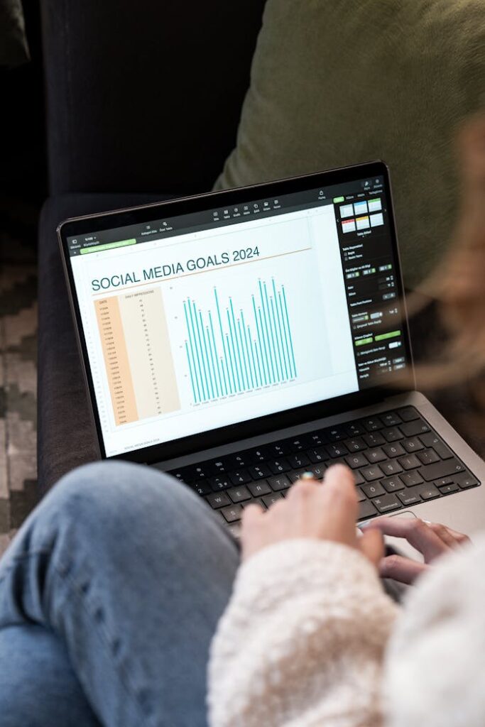 pexels photo 19915765 Woman reviewing 2024 social media goals chart on laptop indoors.
